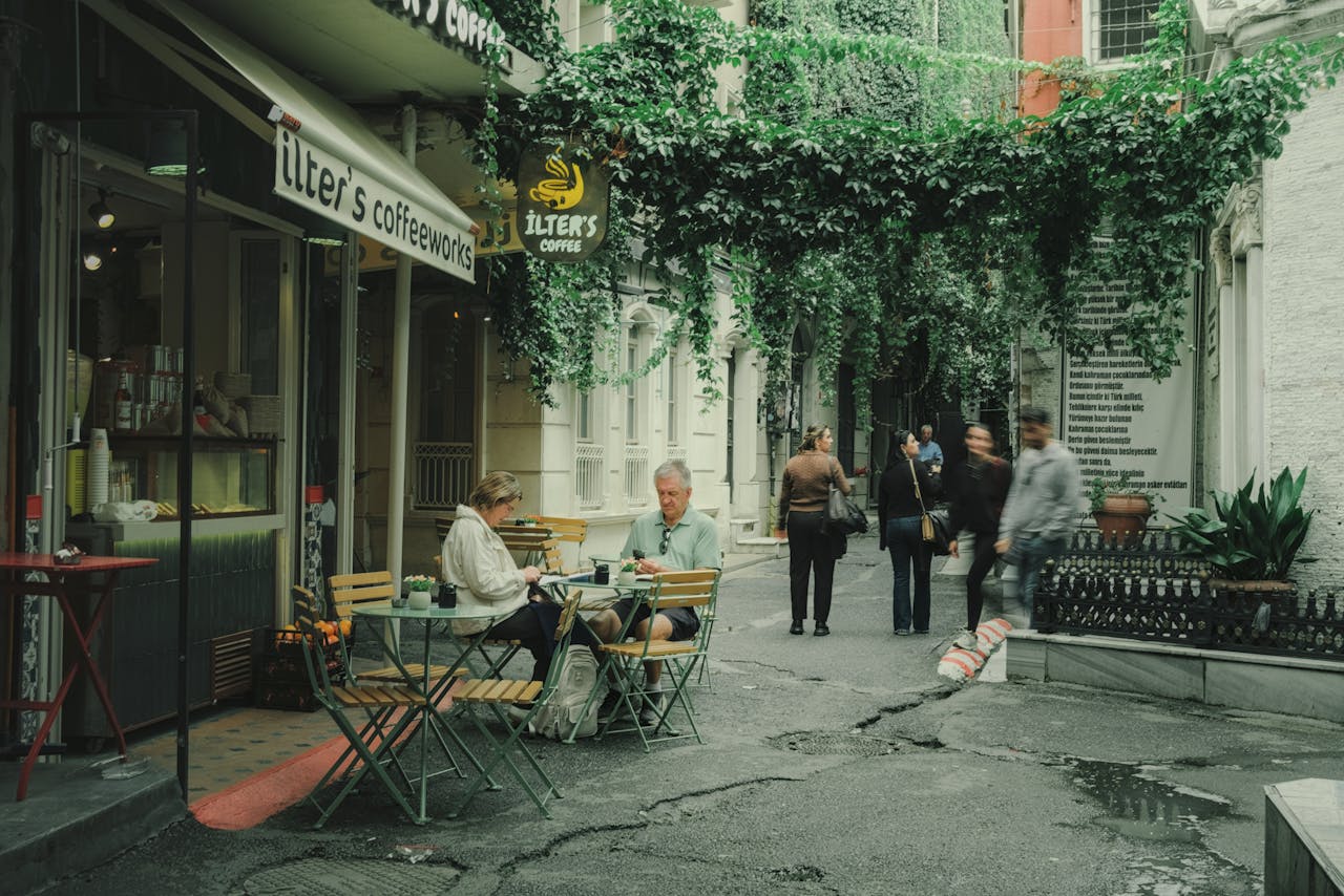 Casual scene at a cozy outdoor coffee shop in a leafy alleyway, perfect for relaxation.
